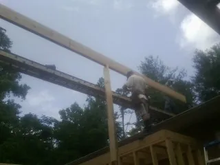 Carpenter setting a ridge beam over a new addition frame — Ice Dam Removal by Roofing Brothers in Chappell Hill