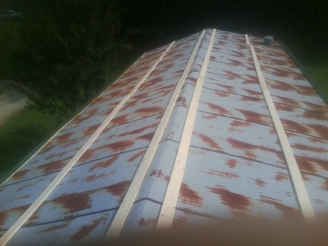 Rusted metal roof panels with new wood purlins before replacement — Storm Damage Roof Repair in Chappell Hill by Roofing Brothers