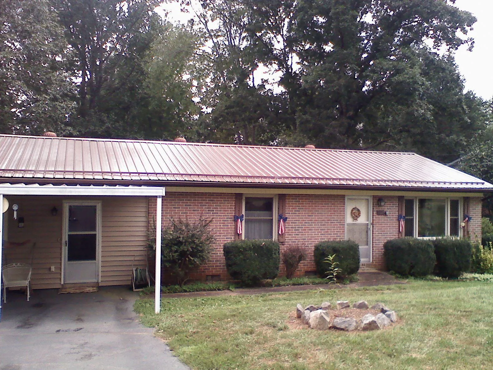 Bronze metal roof and carport on a brick ranch home — Roof Repair work by our crew in Chappell Hill