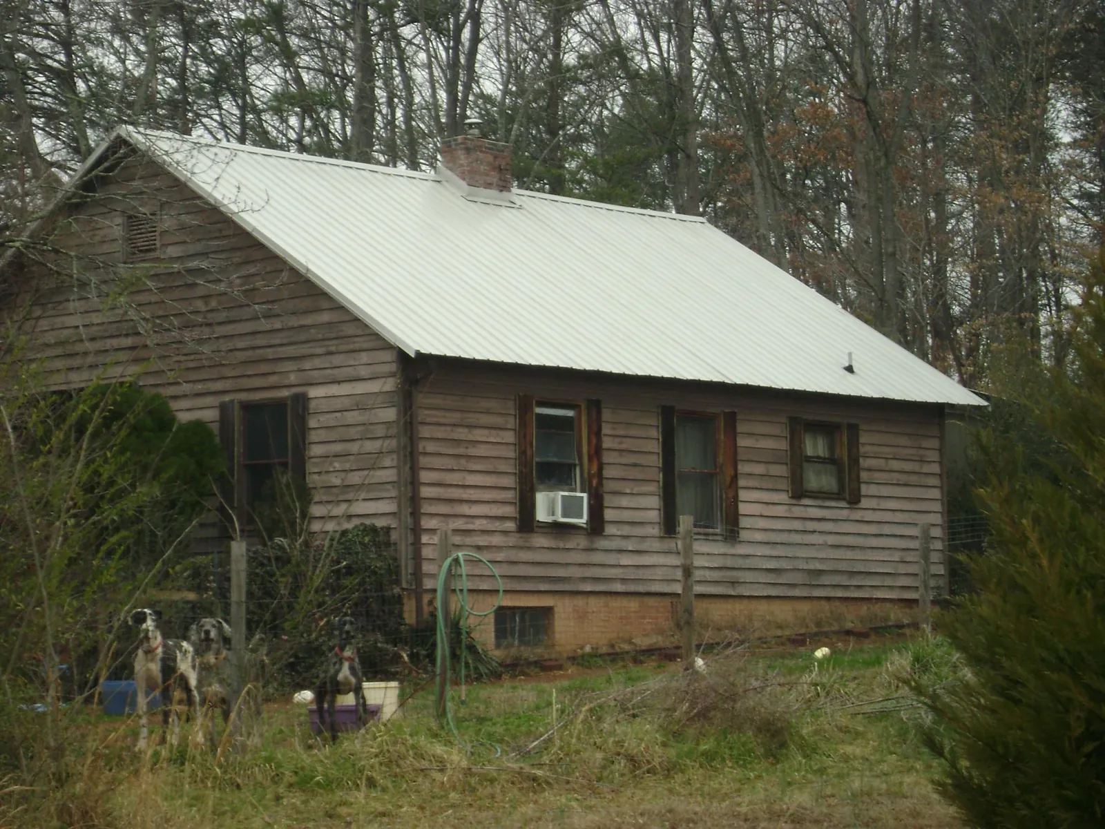 White metal roof on an old wood sided farmhouse, from a Metal Roof Installation job in Chappell Hill
